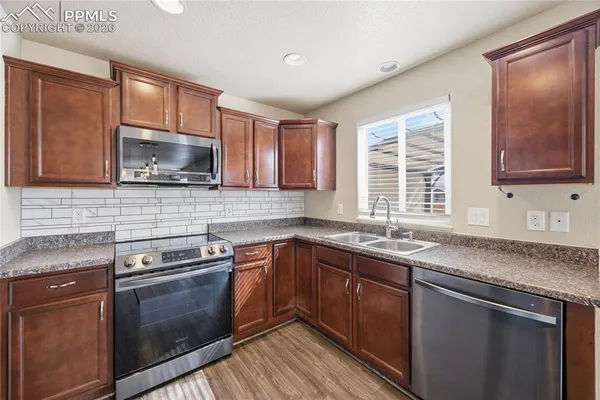 a kitchen with stainless steel appliances granite countertop a sink stove and cabinets