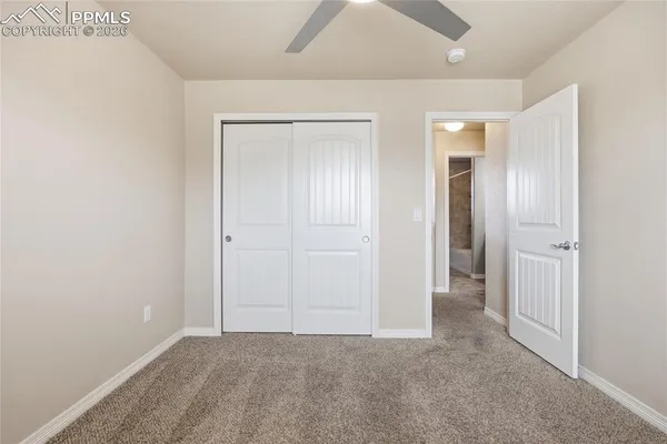 an empty room with fan and entrance