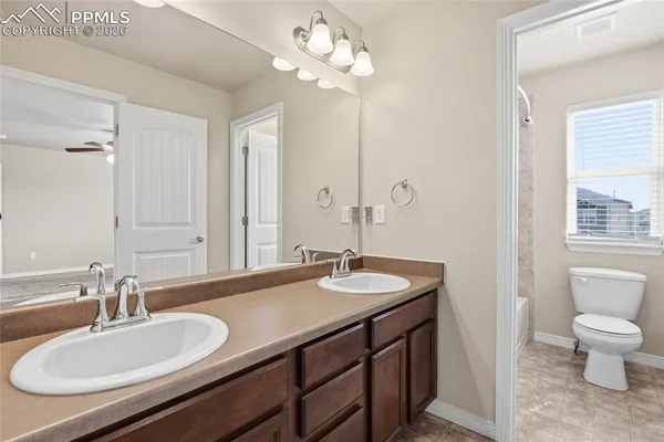 a bathroom with a granite countertop sink a toilet and a mirror