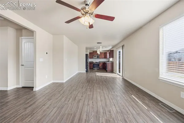 a view of empty room with wooden floor and window