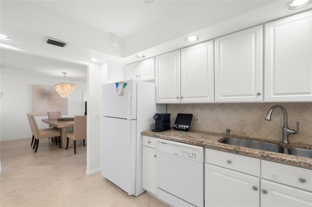 2000 South Ocean Boulevard, Unit 5D Lauderdale-by-the-Sea, FL 33062 - Photo 6 of 27 a white refrigerator freezer sitting in a kitchen