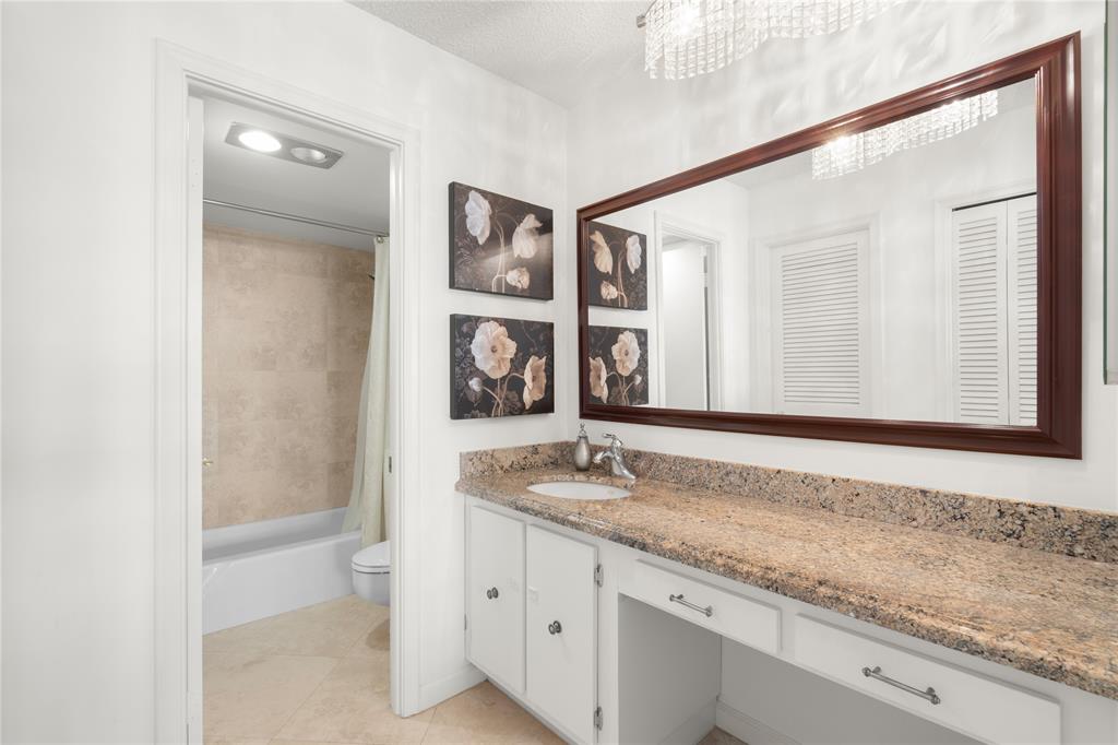 2000 South Ocean Boulevard, Unit 5D Lauderdale-by-the-Sea, FL 33062 - Photo 10 of 27 a bathroom with a granite countertop sink and a mirror