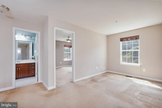 an empty room with windows and a bathroom