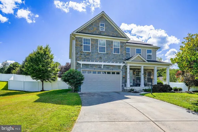 a front view of a house with a yard and potted plants