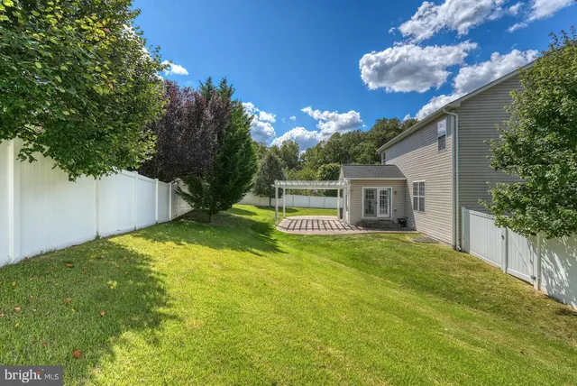 a view of a house with backyard and a tree