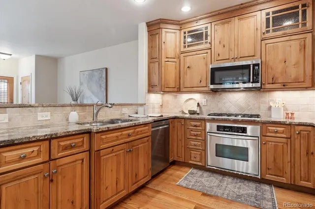 a kitchen with stainless steel appliances granite countertop a sink stove and microwave
