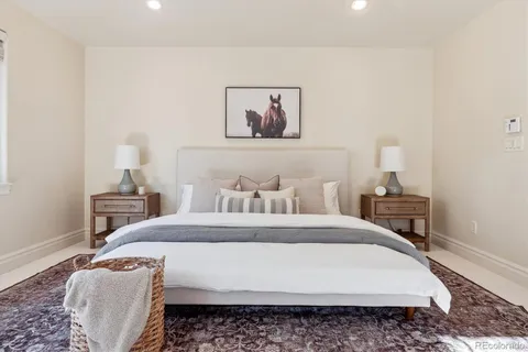 a bedroom with a bed a rug and a lamp