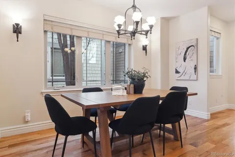 a dining room with furniture a chandelier and wooden floor