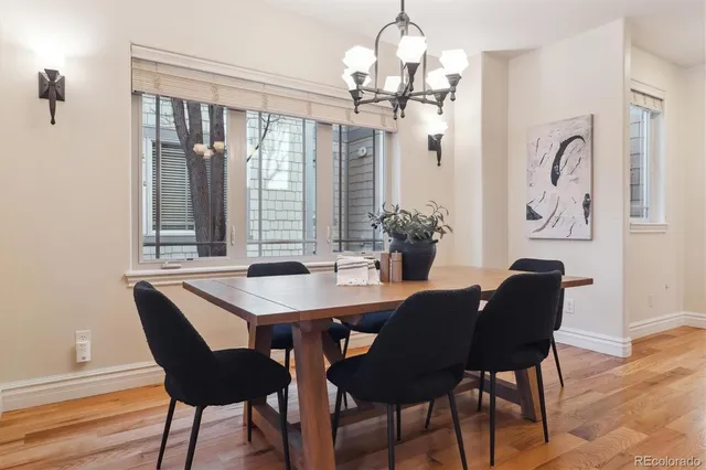 a dining room with furniture a chandelier and wooden floor