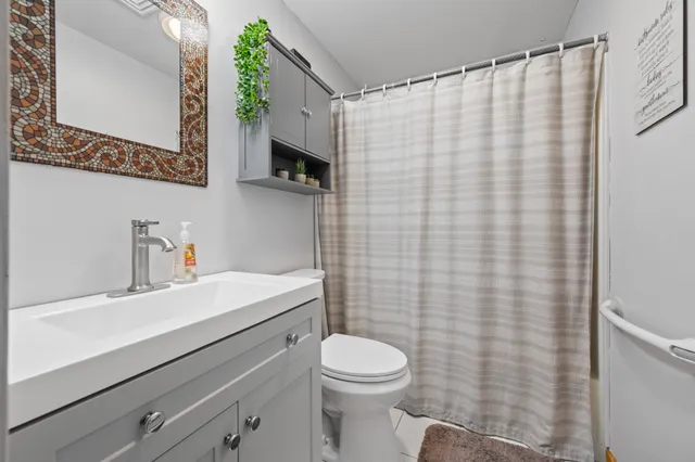 a bathroom with a sink a toilet and shower curtain