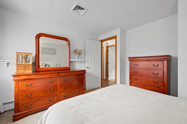 a bedroom with a bed and a mirror on dresser