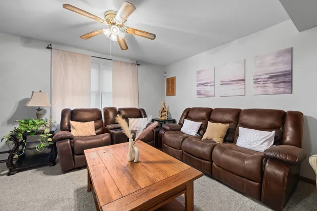 a living room with furniture a chandelier and a potted plant