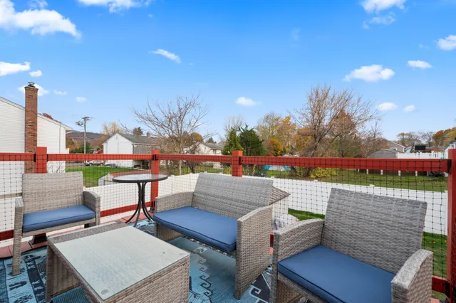 a roof deck with a table and chairs with wooden floor