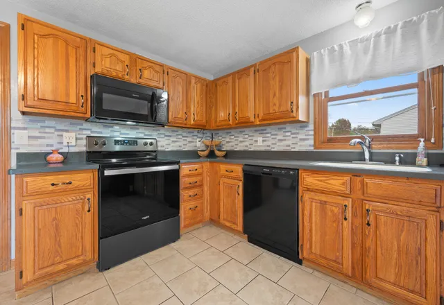 a kitchen with stainless steel appliances granite countertop a stove a sink and a microwave