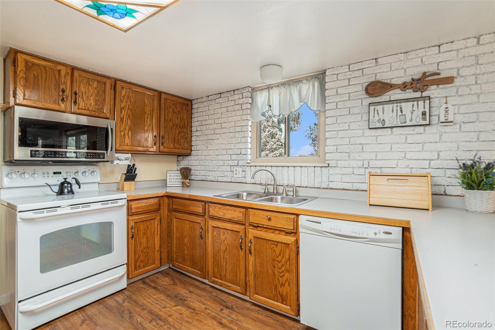 10110 Oak Street Westminster, CO 80021 - Photo 12 of 40 a kitchen with stainless steel appliances a stove microwave and sink