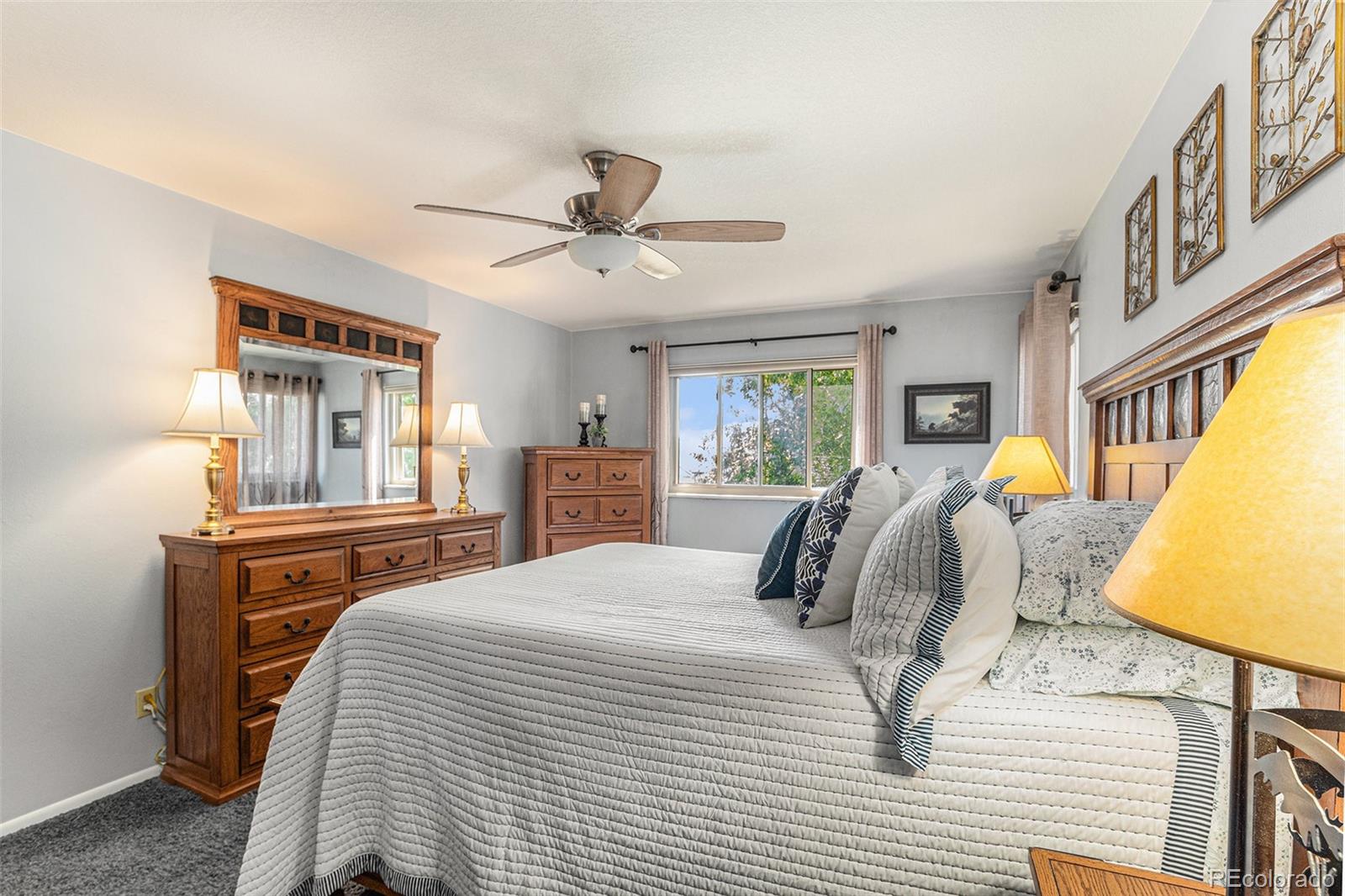 10110 Oak Street Westminster, CO 80021 - Photo 18 of 40 a bedroom with a large bed and a chandelier