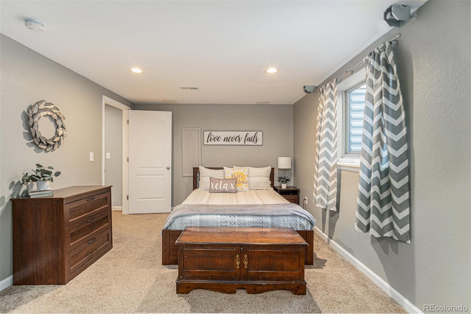 10110 Oak Street Westminster, CO 80021 - Photo 31 of 40 a bedroom with a bed and a chandelier