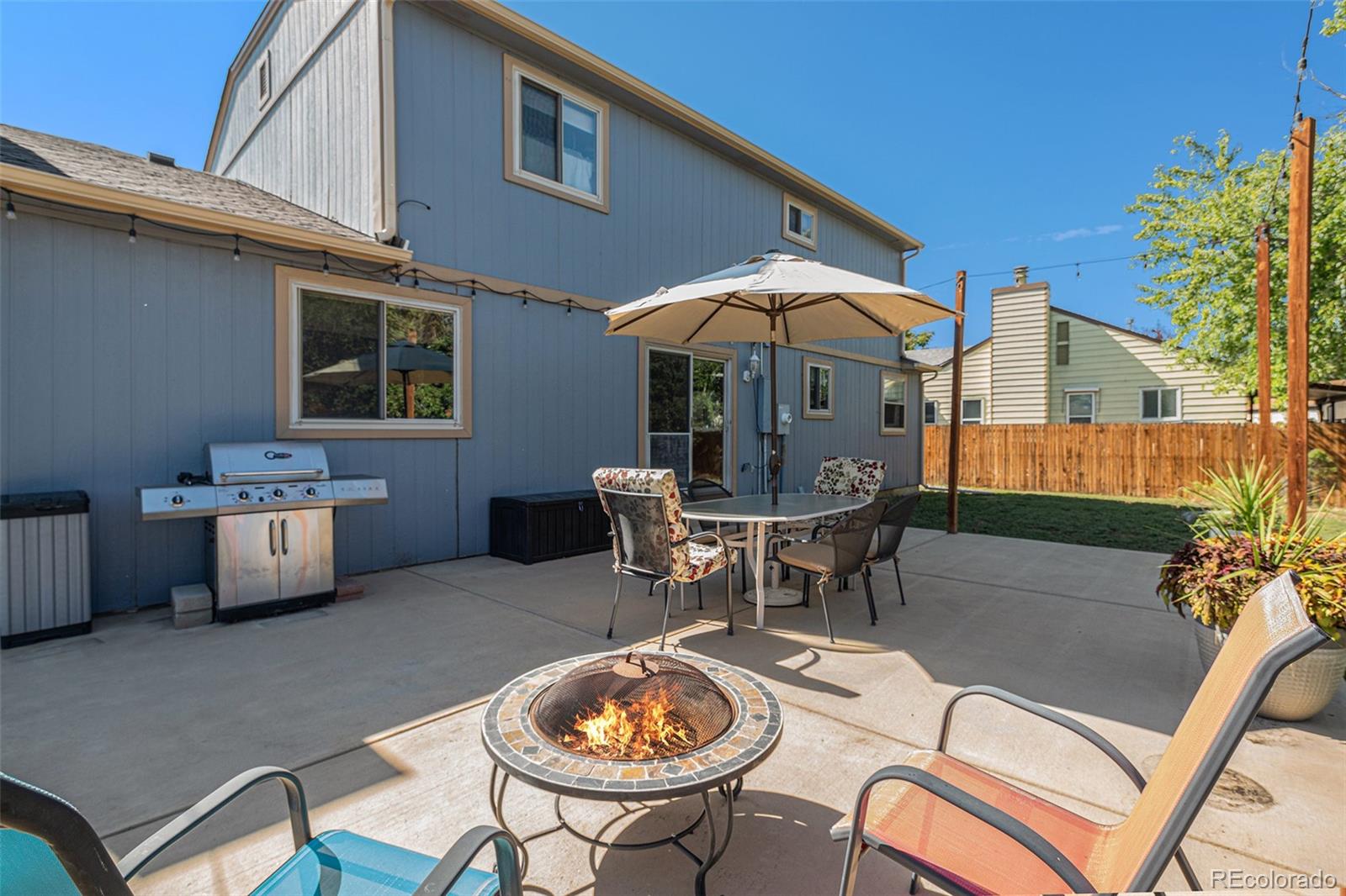 10110 Oak Street Westminster, CO 80021 - Photo 33 of 40 a patio with a table and chairs under an umbrella