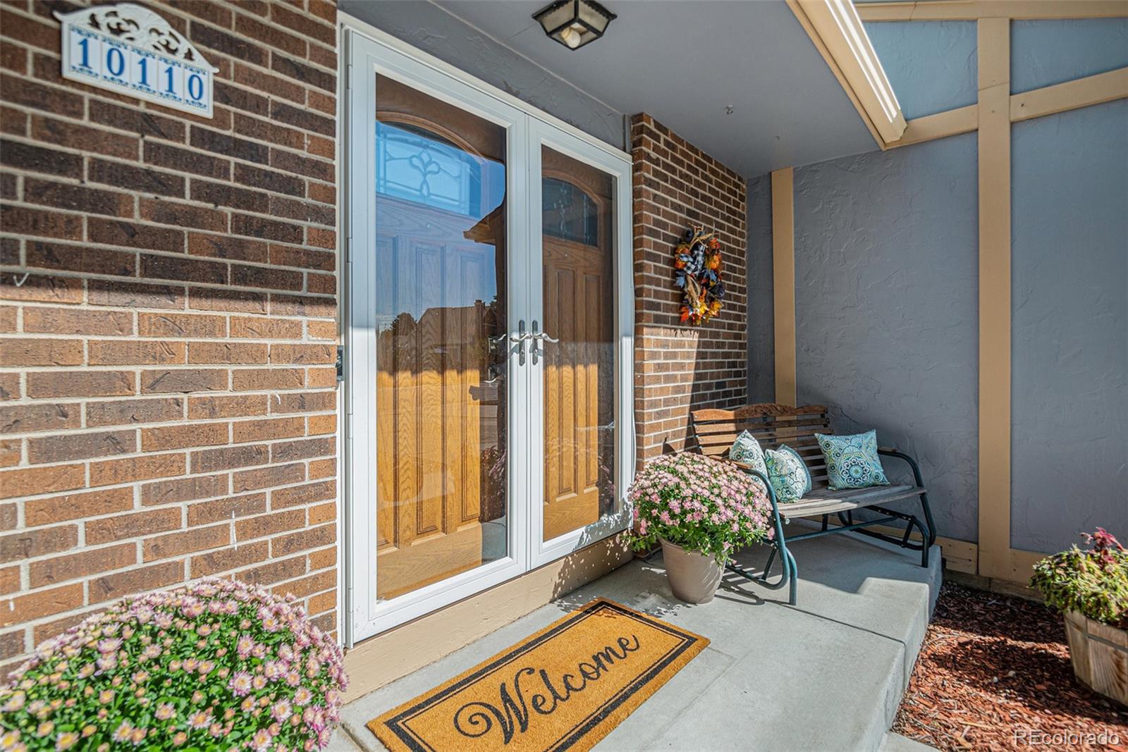 10110 Oak Street Westminster, CO 80021 - Photo 5 of 40 a front view of a house with outdoor seating and flowers