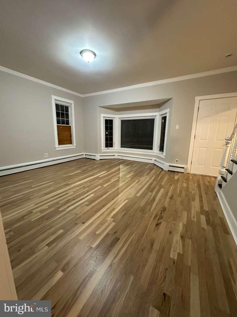 220 Berlin Road Clementon, NJ 08021 - Photo 3 of 15 a view of an empty room with wooden floor and a window
