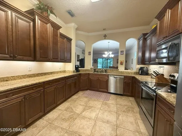 a large kitchen with stainless steel appliances granite countertop a stove sink and cabinets