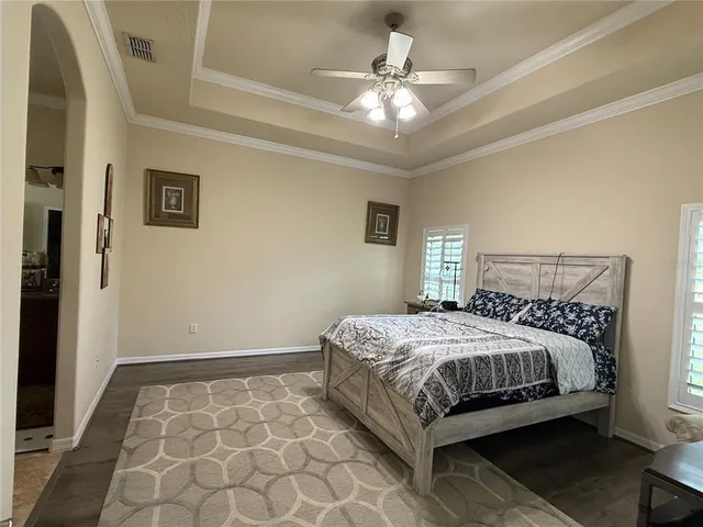 a bedroom with a large bed and a chandelier