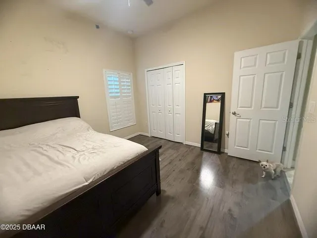 a bedroom with a bed and a wooden floor