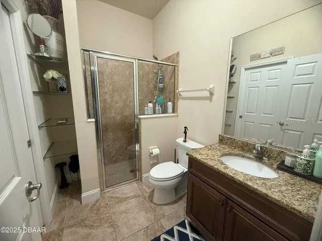 a bathroom with a granite countertop sink toilet and shower