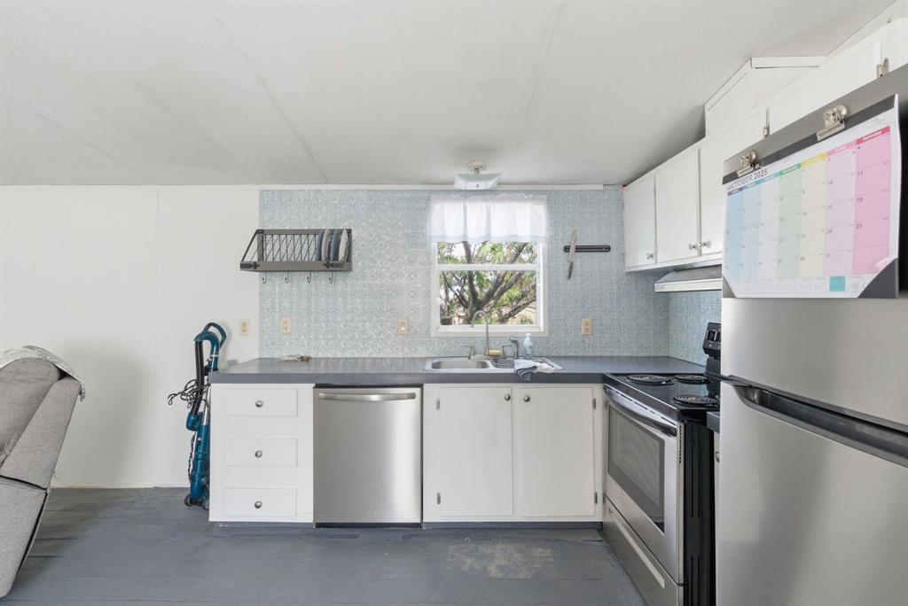 144 Oak Meadows Drive Springtown, TX 76082 - Photo 13 of 24 a kitchen with white cabinets sink and appliances