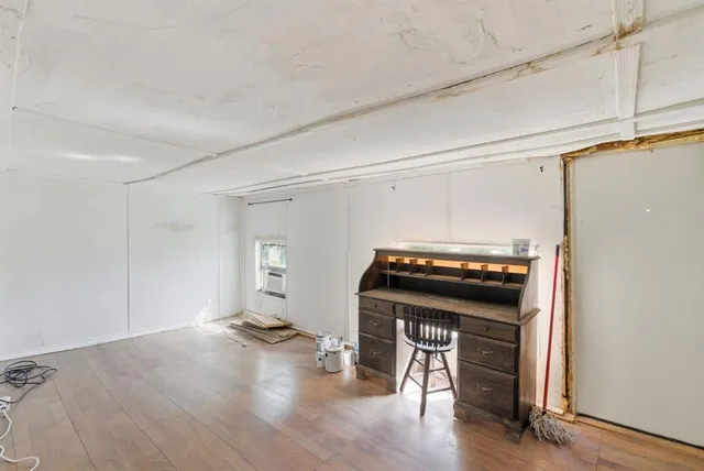 a living room with a stove and wooden floor