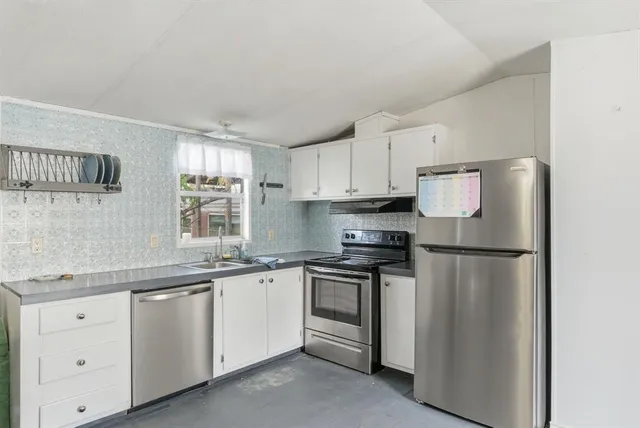 a kitchen with white cabinets and white appliances