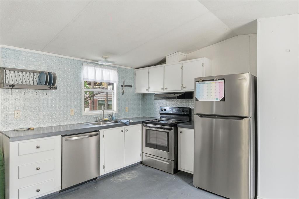 144 Oak Meadows Drive Springtown, TX 76082 - Photo 10 of 24 a kitchen with white cabinets and white appliances