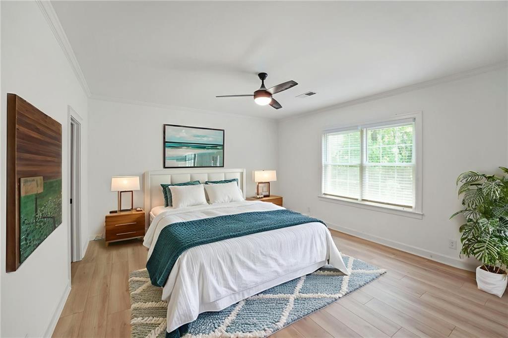 3649 Peachtree Road Northeast, Unit 305 Atlanta, GA 30319 - Photo 14 of 58 a bedroom with a large bed and a chandelier