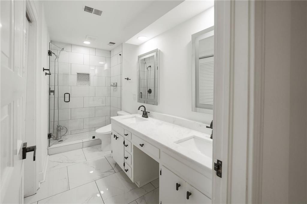 3649 Peachtree Road Northeast, Unit 305 Atlanta, GA 30319 - Photo 31 of 58 a spacious bathroom with a shower sink double and mirror