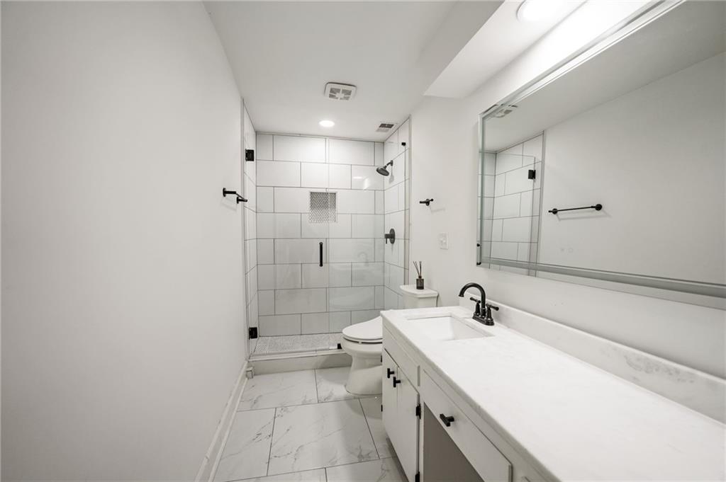3649 Peachtree Road Northeast, Unit 305 Atlanta, GA 30319 - Photo 32 of 58 a bathroom with a double vanity sink toilet and shower