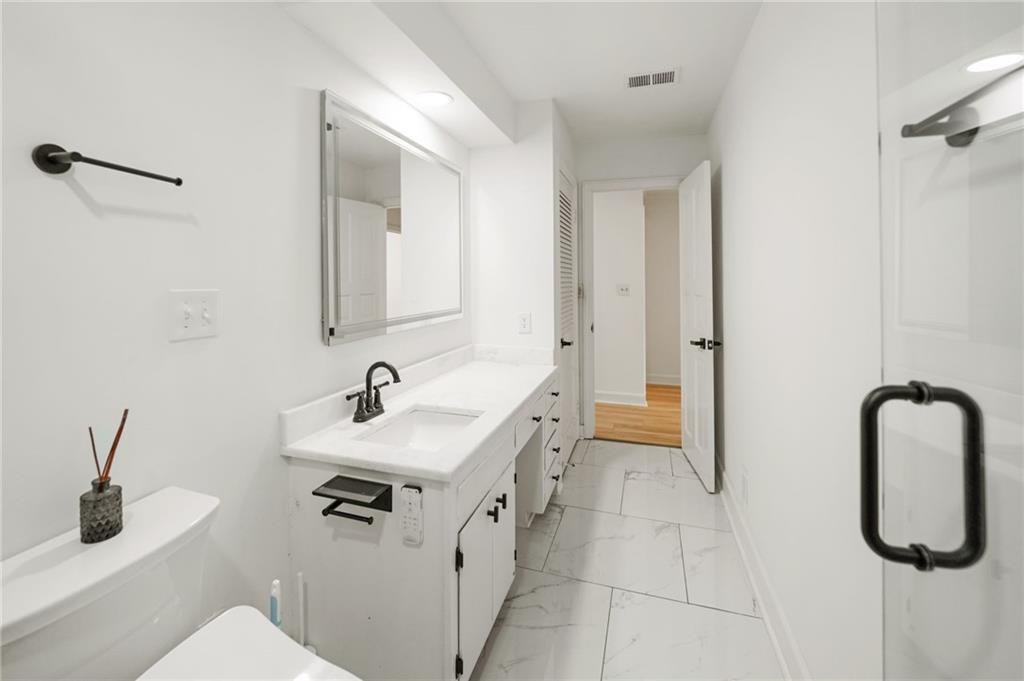 3649 Peachtree Road Northeast, Unit 305 Atlanta, GA 30319 - Photo 33 of 58 a bathroom with a sink a toilet and mirror