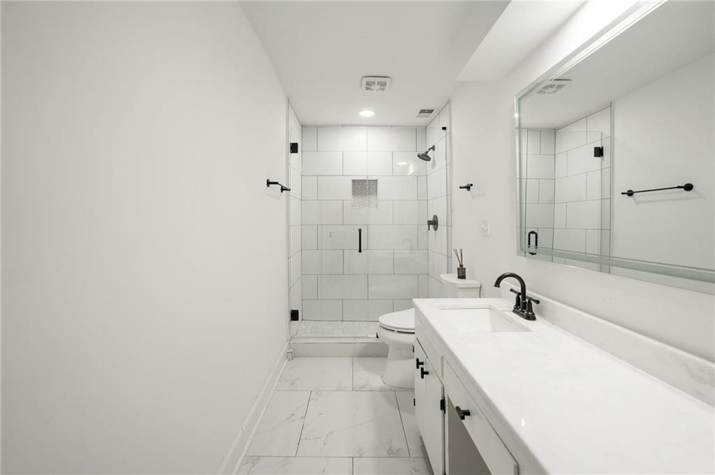 3649 Peachtree Road Northeast, Unit 305 Atlanta, GA 30319 - Photo 34 of 58 a bathroom with a sink a toilet and shower