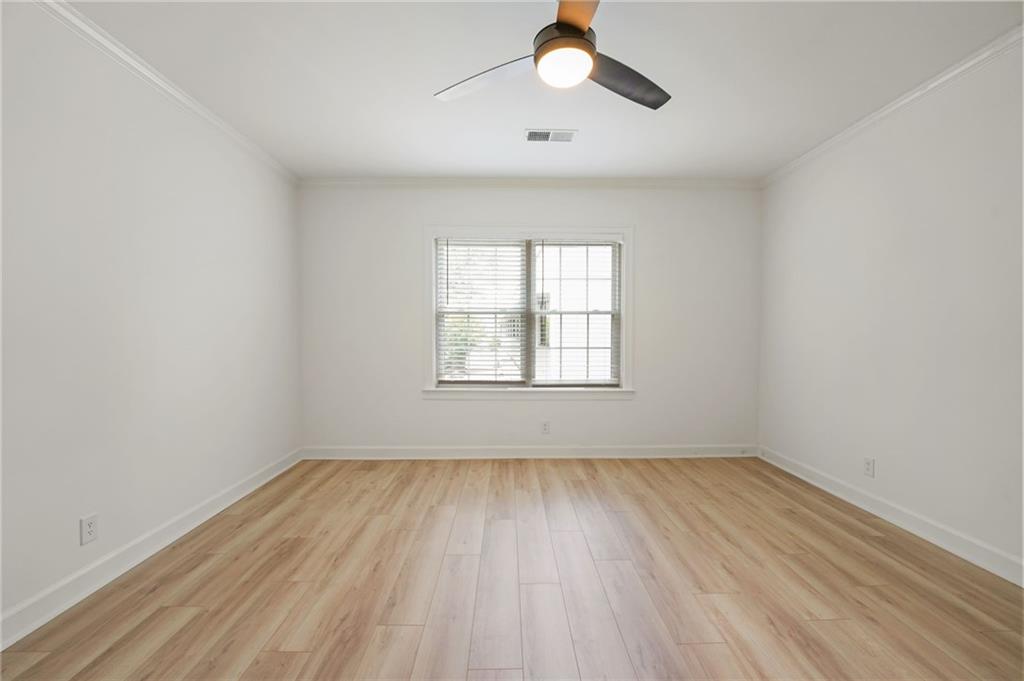 3649 Peachtree Road Northeast, Unit 305 Atlanta, GA 30319 - Photo 37 of 58 an empty room with wooden floor fan and windows