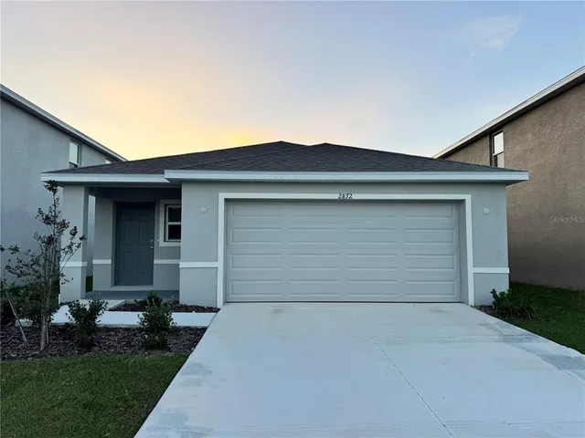 a large white kitchen with kitchen island a stove a sink a microwave and a refrigerator