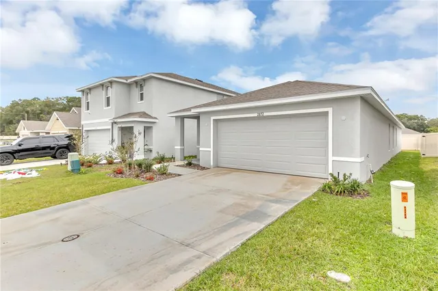 a front view of a house with a yard and garage