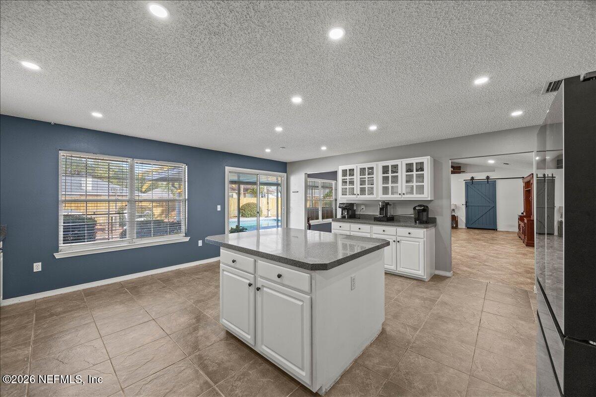 9750 Brockham Court Jacksonville, FL 32221 - Photo 16 of 39 a large kitchen with kitchen island a sink a counter top and stainless steel appliances