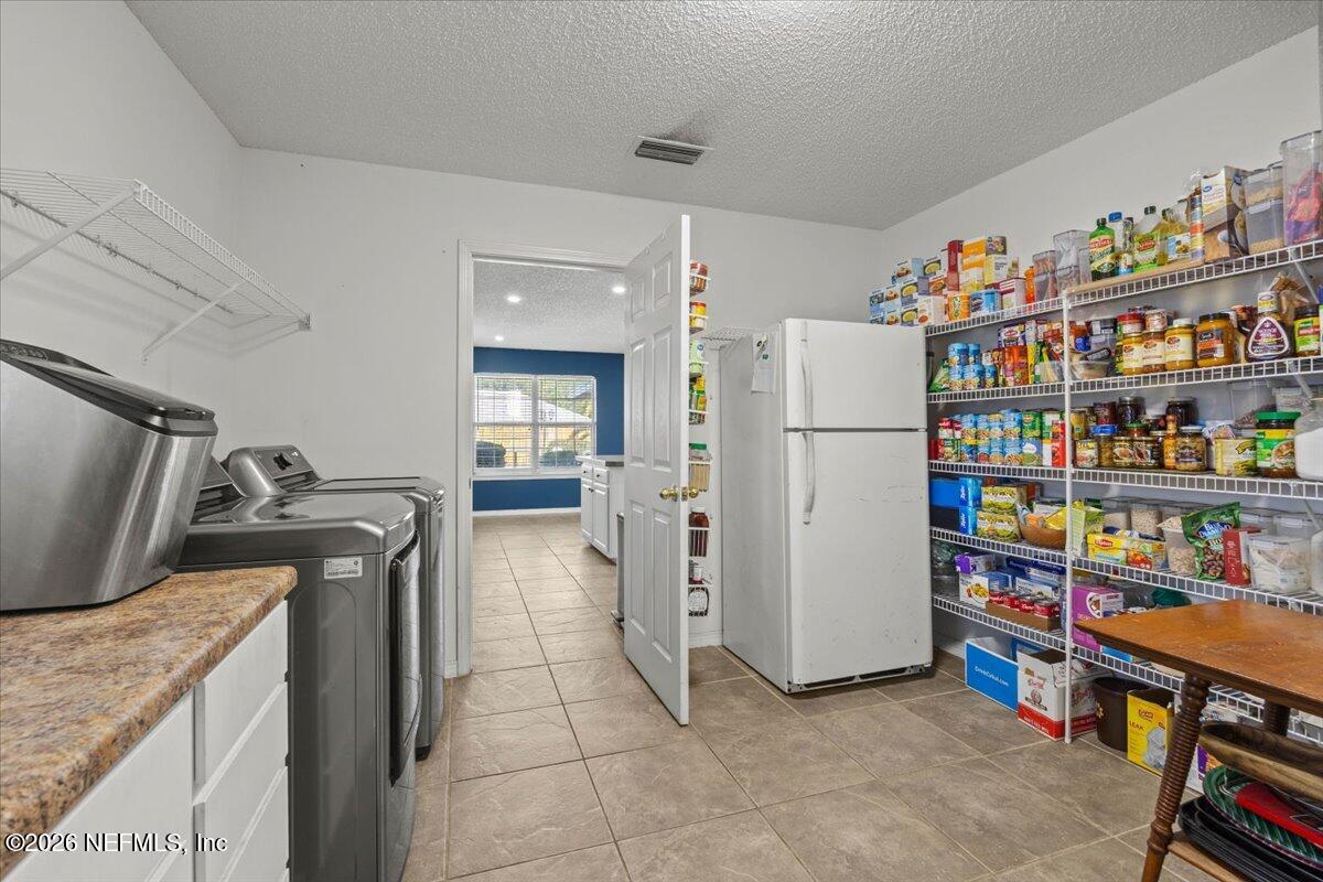 9750 Brockham Court Jacksonville, FL 32221 - Photo 23 of 39 a kitchen with refrigerator and cabinets