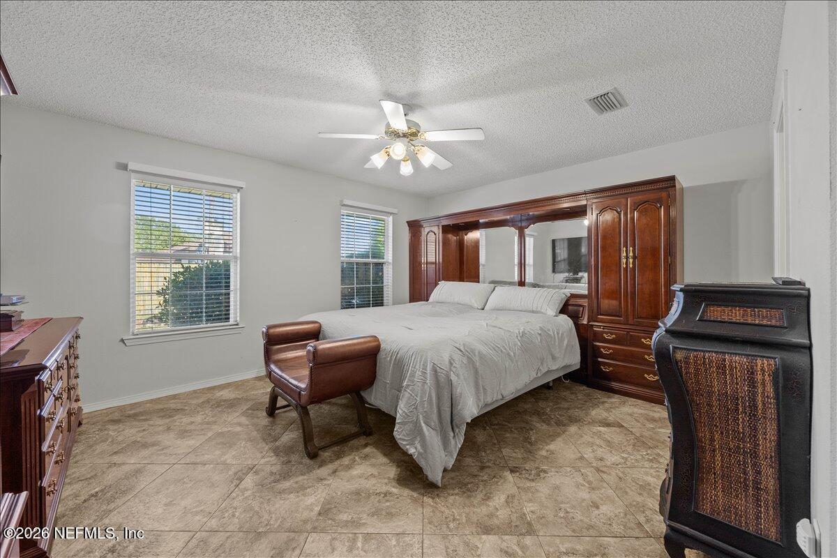 9750 Brockham Court Jacksonville, FL 32221 - Photo 24 of 39 a bedroom with a bed and a chandelier