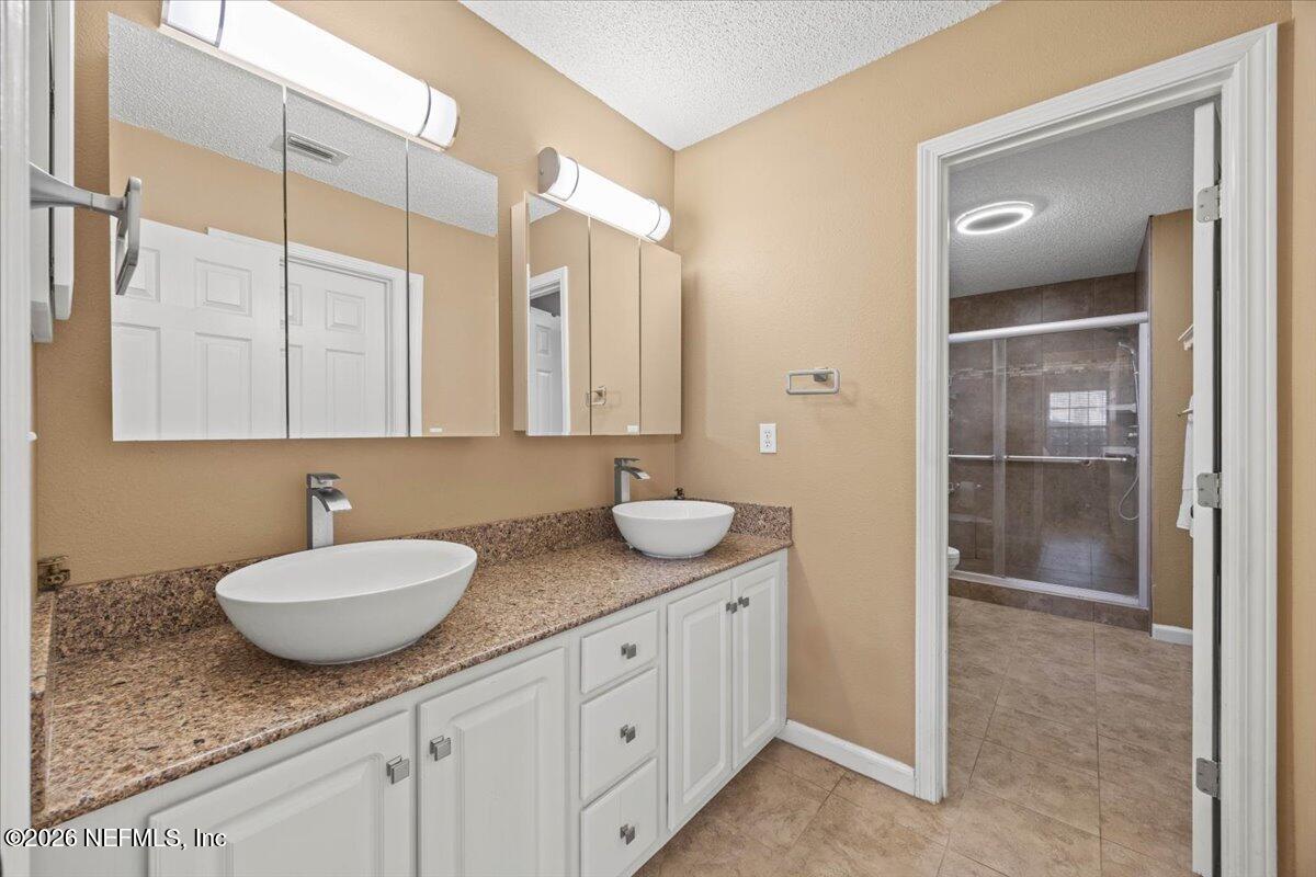 9750 Brockham Court Jacksonville, FL 32221 - Photo 27 of 39 a bathroom with a granite countertop sink and a mirror