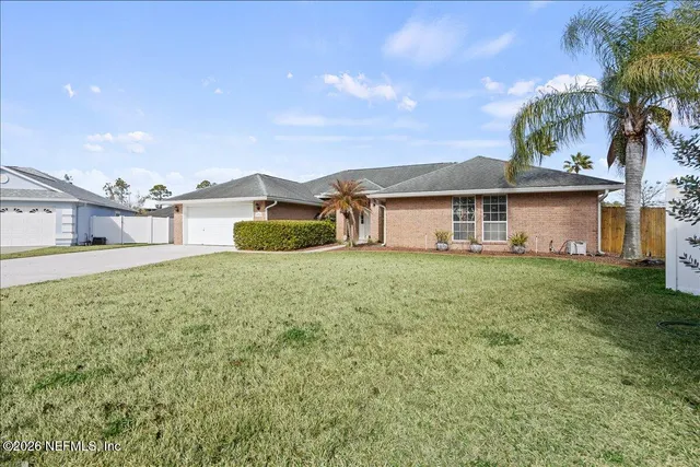 a white house with a big yard and large trees