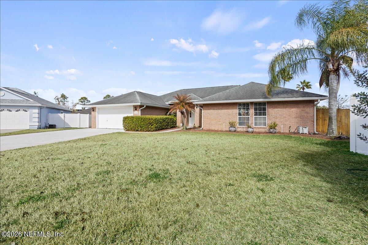 9750 Brockham Court Jacksonville, FL 32221 - Photo 3 of 39 a white house with a big yard and large trees