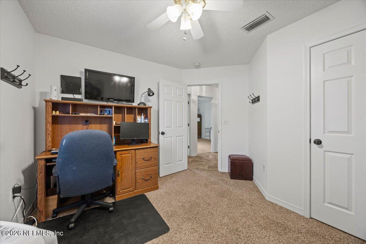 9750 Brockham Court Jacksonville, FL 32221 - Photo 31 of 39 a bedroom with furniture flat screen tv and window