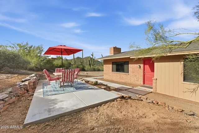 a patio with a table and chairs under an umbrella