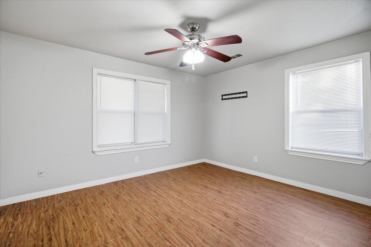 4115 31st Street Lubbock, TX 79410 - Photo 11 of 16 a view of an empty room with wooden floor and a window