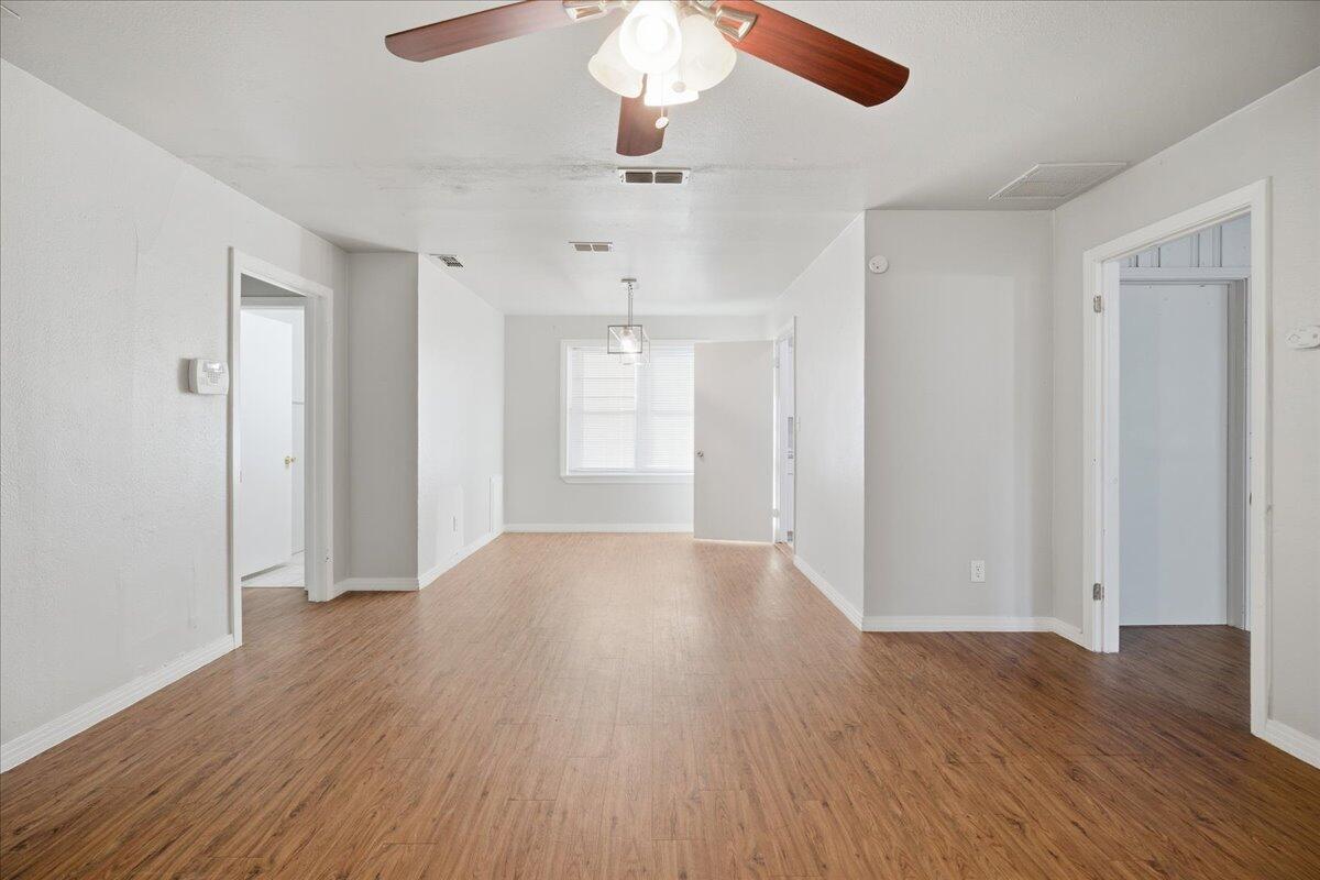 4115 31st Street Lubbock, TX 79410 - Photo 2 of 16 wooden floor in an empty room with a window